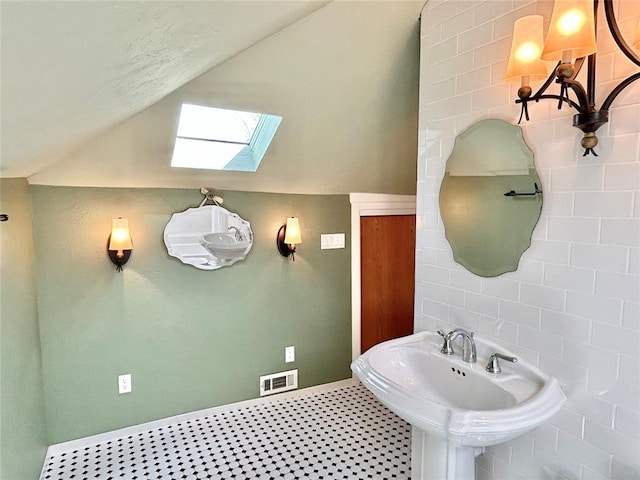 1909 N Gatewood Ave, Oklahoma City, OK 73106 - bathroom with tile walls, a sink, visible vents, and lofted ceiling with skylight