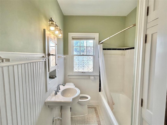 1909 N Gatewood Ave, Oklahoma City, OK 73106 - full bathroom with toilet, tile patterned floors, shower / bath combo with shower curtain, and a wainscoted wall
