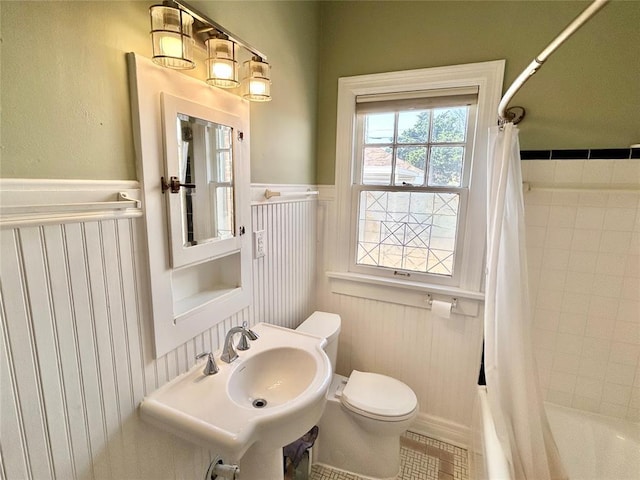 1909 N Gatewood Ave, Oklahoma City, OK 73106 - bathroom featuring shower / bath combo, toilet, wainscoting, and a sink