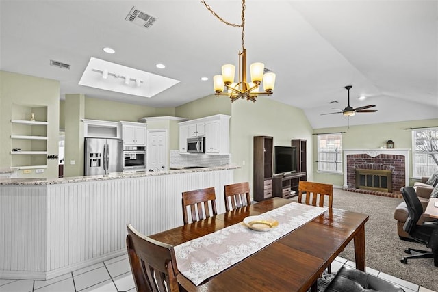 4113 Annalane Dr, Norman, OK 73072 - dining space with ceiling fan with notable chandelier, visible vents, built in features, and a brick fireplace