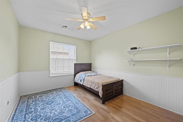 4113 Annalane Dr, Norman, OK 73072 - bedroom with a ceiling fan, a wainscoted wall, wood finished floors, and visible vents