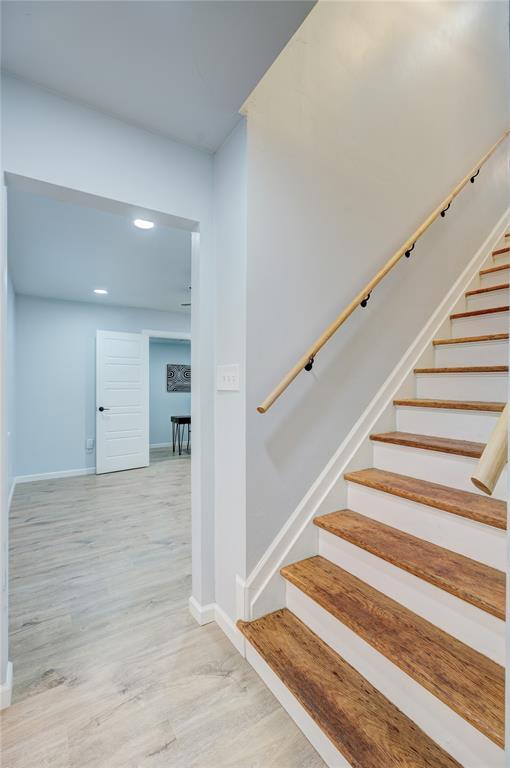 staircase with baseboards and wood finished floors