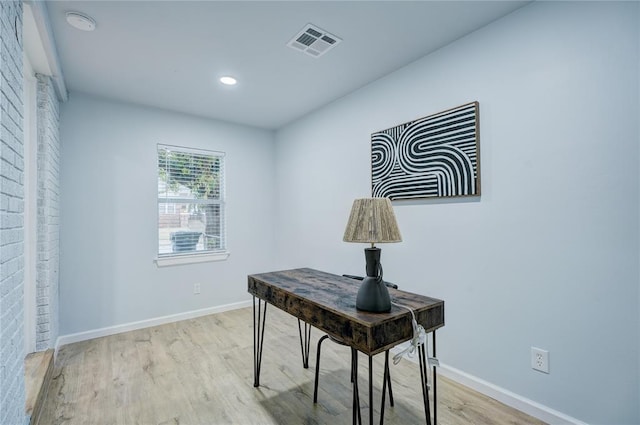 office space featuring wood finished floors, baseboards, and visible vents