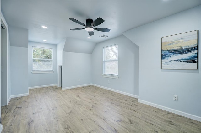additional living space featuring plenty of natural light, baseboards, visible vents, and wood finished floors
