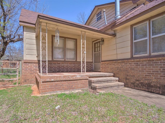 27704 S County Line Ave, Blanchard, OK 73010 - doorway to property with brick siding, fence, a shingled roof, and covered porch