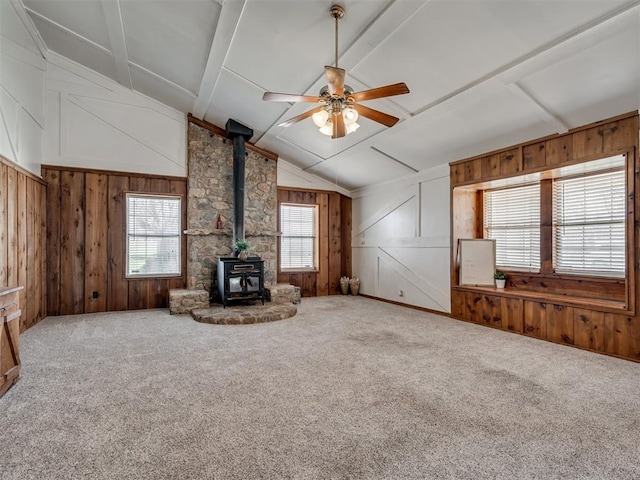 27704 S County Line Ave, Blanchard, OK 73010 - unfurnished living room with a ceiling fan, vaulted ceiling with beams, a wood stove, wood walls, and carpet flooring