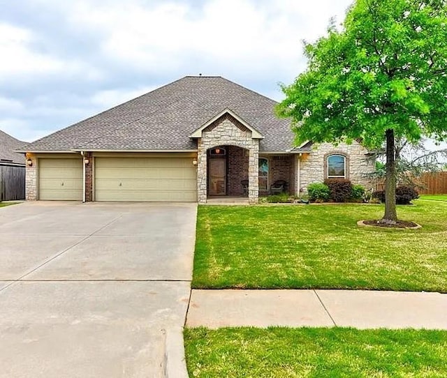 904 Majestic St, Yukon, OK 73099 - french country inspired facade with stone siding, concrete driveway, a garage, and a shingled roof