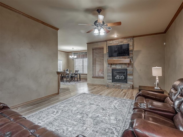 904 Majestic St, Yukon, OK 73099 - living area featuring ornamental molding, ceiling fan, wood finished floors, a stone fireplace, and a chandelier