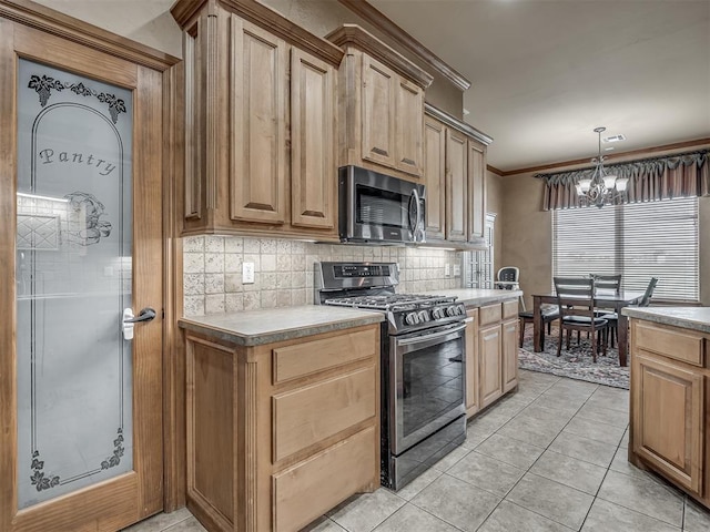 904 Majestic St, Yukon, OK 73099 - kitchen featuring stainless steel appliances, decorative backsplash, a chandelier, light tile patterned floors, and crown molding