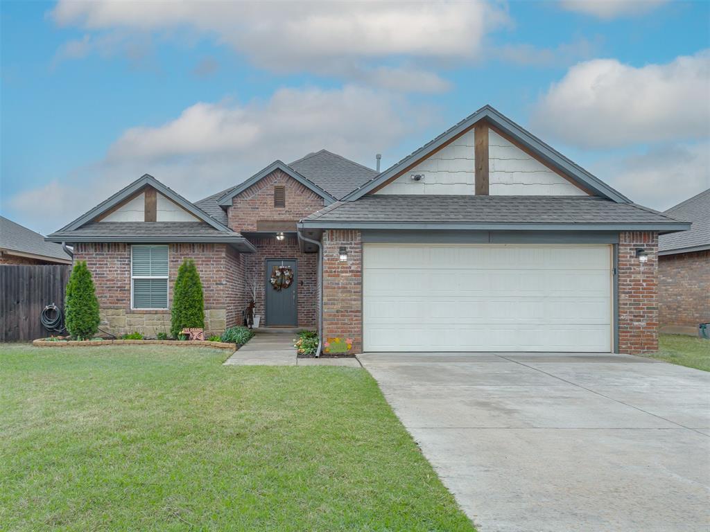 10012 SW 22nd St, Yukon, OK 73099 - view of front of home featuring driveway, roof with shingles, brick siding, a front lawn, and a garage