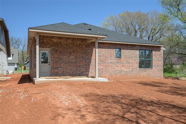 128 E 7th St, Arcadia, OK 73007 - back of property featuring roof with shingles and brick siding