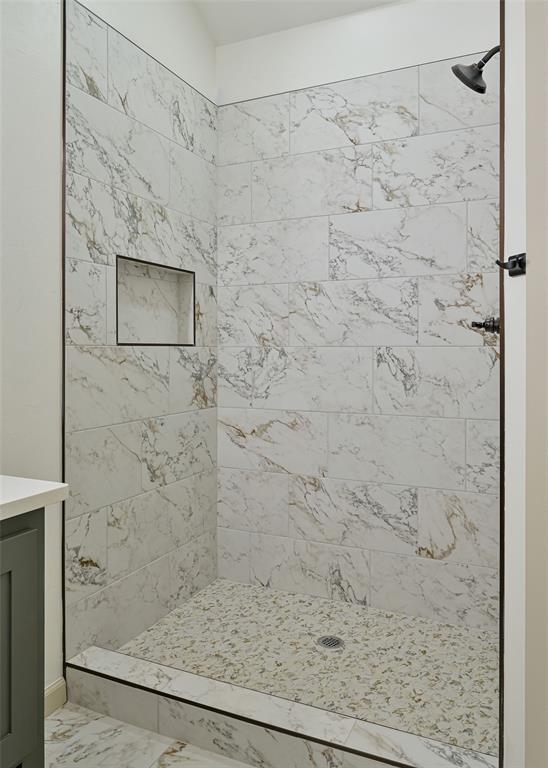 128 E 7th St, Arcadia, OK 73007 - bathroom with a tile shower, marble look tile flooring, and vanity