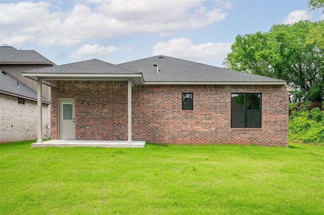 128 E 7th St, Arcadia, OK 73007 - rear view of house featuring a yard, brick siding, a patio area, and roof with shingles