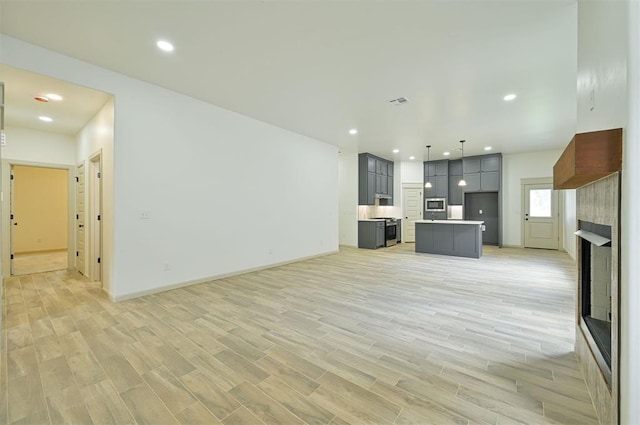 128 E 7th St, Arcadia, OK 73007 - unfurnished living room with light wood-style floors, a large fireplace, baseboards, and recessed lighting