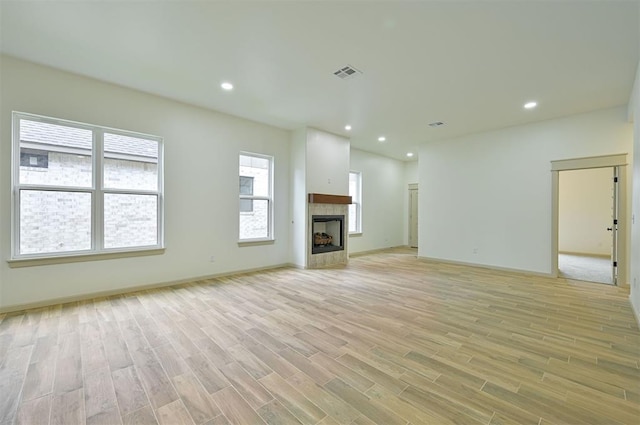 128 E 7th St, Arcadia, OK 73007 - unfurnished living room featuring light wood finished floors, recessed lighting, a tiled fireplace, and baseboards
