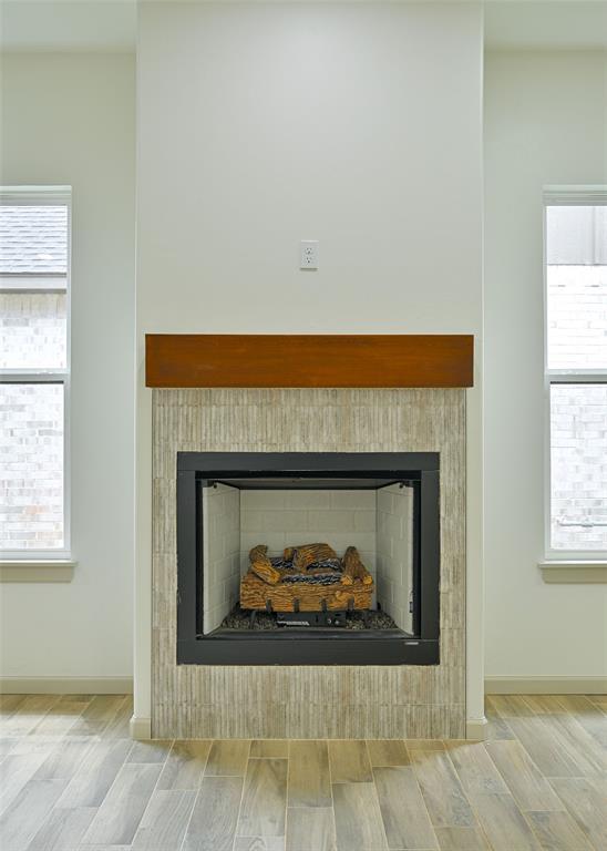 128 E 7th St, Arcadia, OK 73007 - detailed view of a fireplace, wood finished floors, and baseboards