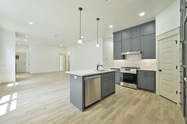 128 E 7th St, Arcadia, OK 73007 - kitchen with appliances with stainless steel finishes, gray cabinetry, a sink, decorative backsplash, and an island with sink