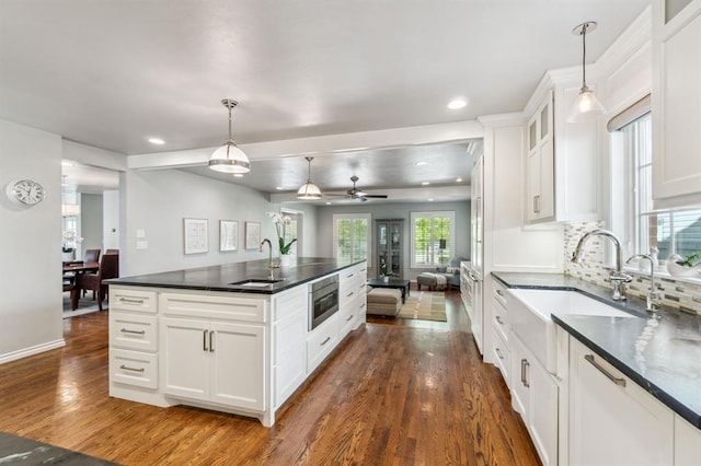 1707 Pennington Way, Nichols Hills, OK 73116 - kitchen with stainless steel microwave, dark countertops, a sink, dark wood-type flooring, and recessed lighting