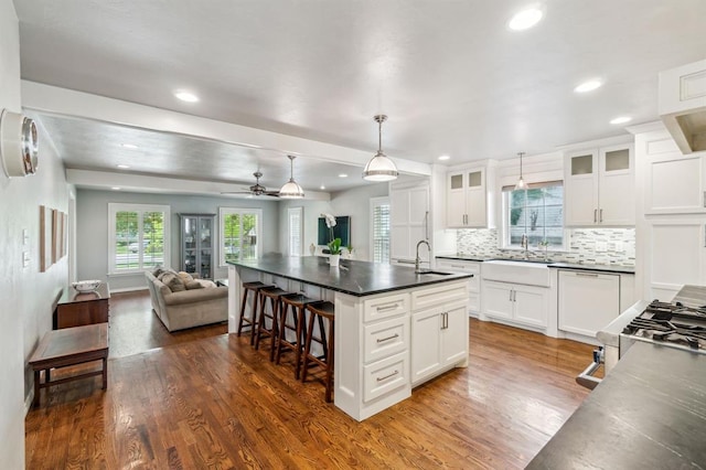 1707 Pennington Way, Nichols Hills, OK 73116 - kitchen with open floor plan, dark countertops, a sink, dark wood-type flooring, and recessed lighting