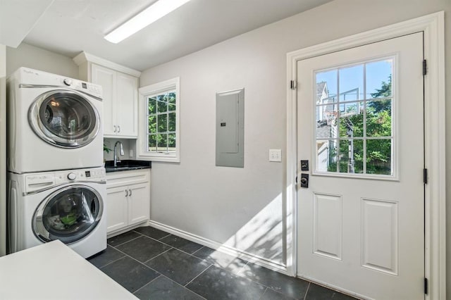1707 Pennington Way, Nichols Hills, OK 73116 - laundry room with stacked washer / drying machine, electric panel, cabinet space, baseboards, and dark tile patterned flooring