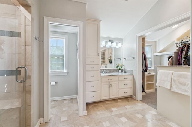 1707 Pennington Way, Nichols Hills, OK 73116 - bathroom featuring a walk in closet, vanity, a stall shower, and baseboards