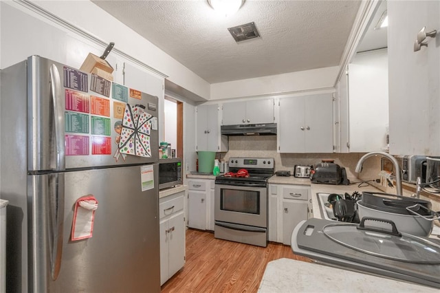 103 W Thompson Dr, Kingfisher, OK 73750 - kitchen with light wood-style flooring, visible vents, appliances with stainless steel finishes, under cabinet range hood, and light countertops