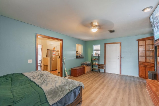 103 W Thompson Dr, Kingfisher, OK 73750 - bedroom with light wood-style floors, freestanding refrigerator, a ceiling fan, and visible vents