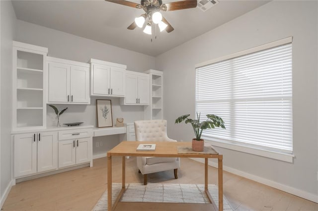 office space featuring baseboards, light wood-style flooring, visible vents, and ceiling fan