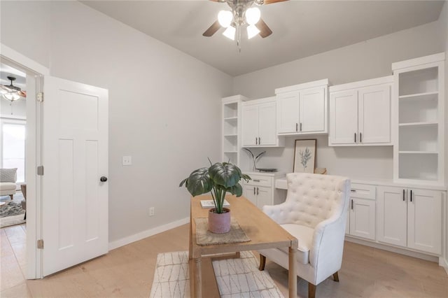 dining area featuring baseboards, ceiling fan, and light wood-style floors