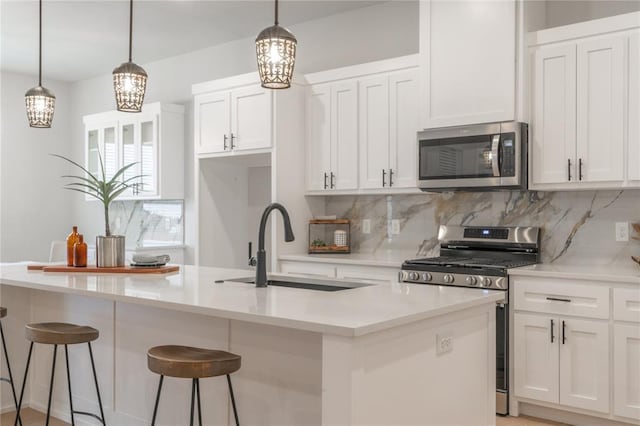 kitchen with backsplash, a sink, appliances with stainless steel finishes, and a chandelier