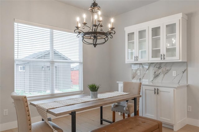 dining room with baseboards, a chandelier, and light wood-type flooring