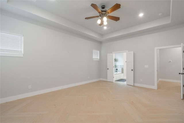 spare room featuring baseboards, recessed lighting, a ceiling fan, and a raised ceiling