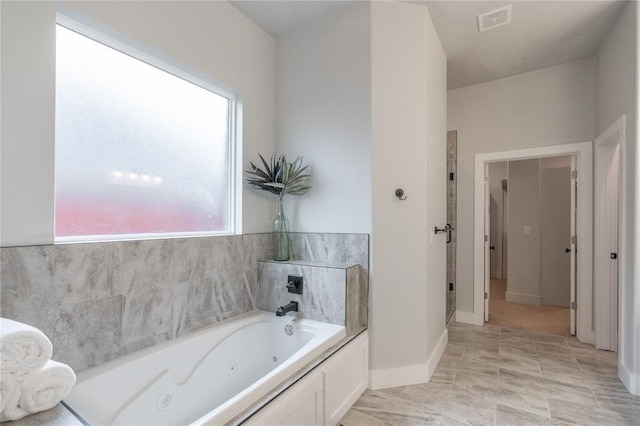 bathroom with a tub with jets and visible vents