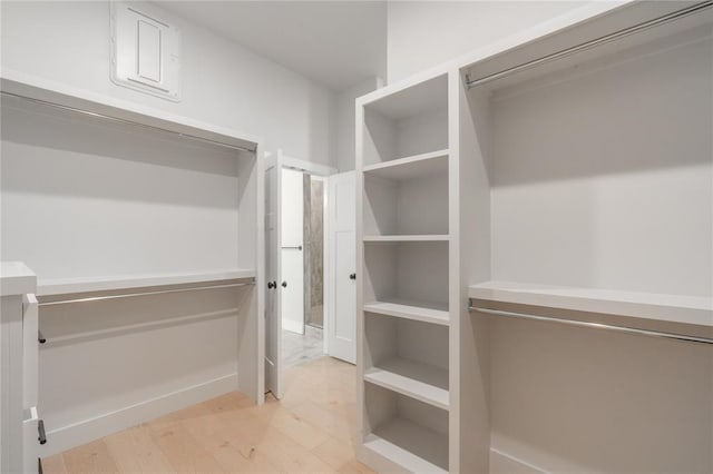 walk in closet with wood finished floors