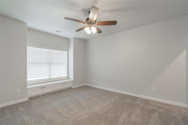 empty room with light carpet, baseboards, ceiling fan, and visible vents