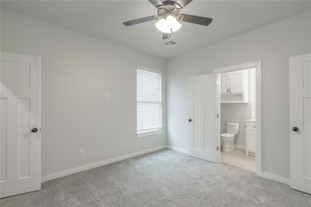 unfurnished bedroom featuring connected bathroom, light carpet, baseboards, visible vents, and ceiling fan
