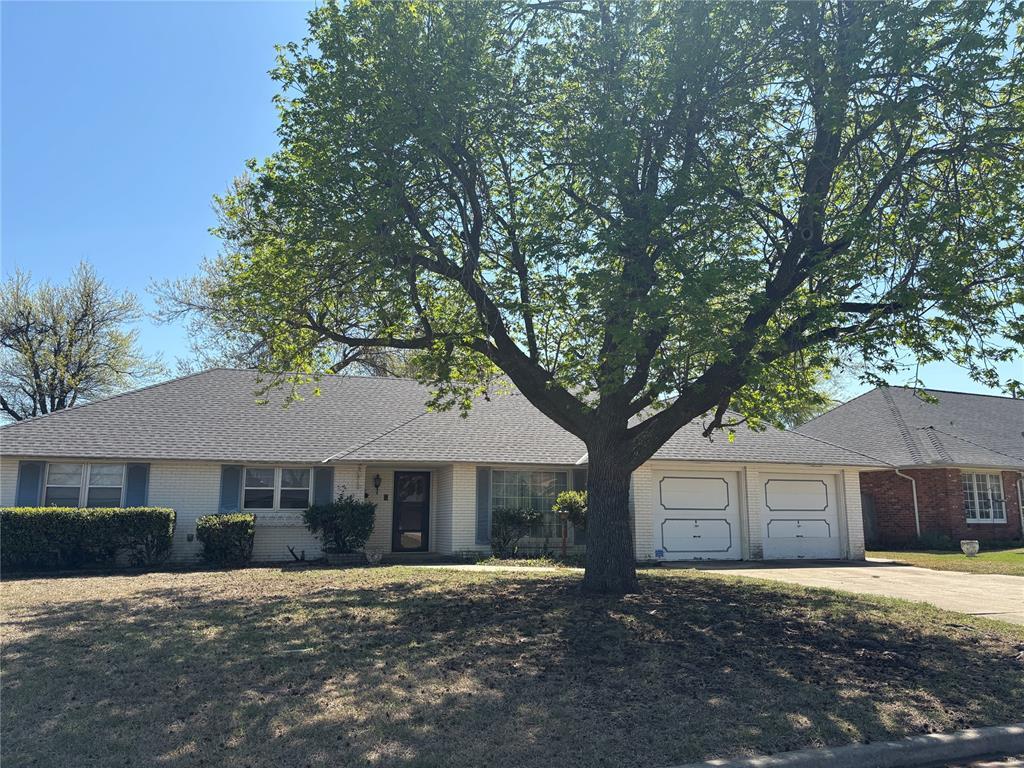 ranch-style house featuring brick siding, driveway, and an attached garage