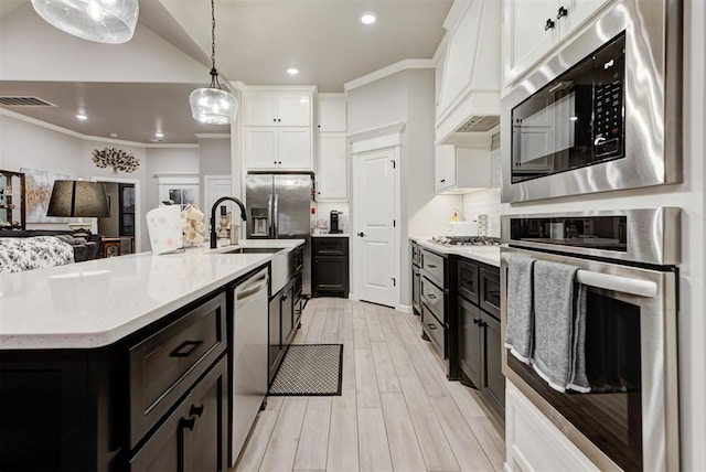 5513 Carmel Creek Dr, Mustang, OK 73064 - kitchen with stainless steel appliances, white cabinetry, custom exhaust hood, light wood-style flooring, and recessed lighting