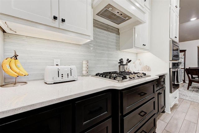 5513 Carmel Creek Dr, Mustang, OK 73064 - kitchen with stainless steel appliances, white cabinetry, custom range hood, and decorative backsplash