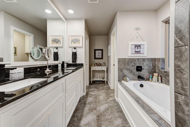 5513 Carmel Creek Dr, Mustang, OK 73064 - full bath with double vanity, a garden tub, baseboards, and recessed lighting