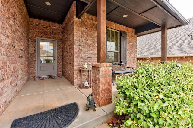 5513 Carmel Creek Dr, Mustang, OK 73064 - property entrance with brick siding, covered porch, and roof with shingles