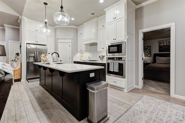 5513 Carmel Creek Dr, Mustang, OK 73064 - kitchen with stainless steel appliances, light wood finished floors, light countertops, white cabinetry, and recessed lighting