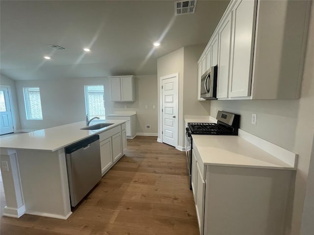 kitchen with light wood-style flooring, a sink, stainless steel appliances, and visible vents