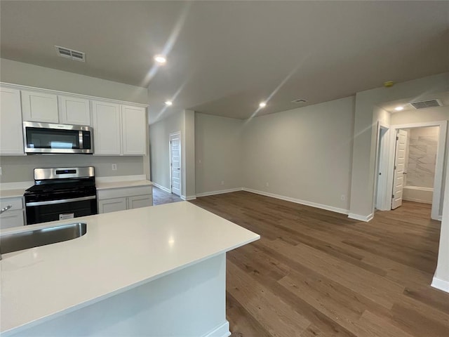 kitchen with white cabinetry, light countertops, recessed lighting, light wood-type flooring, and appliances with stainless steel finishes