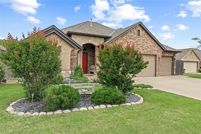 11609 SW 14th St, Yukon, OK 73099 - french country inspired facade with a garage, concrete driveway, a front yard, a shingled roof, and stone siding