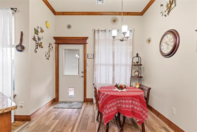 11609 SW 14th St, Yukon, OK 73099 - dining room featuring ornamental molding, light wood-style floors, a chandelier, healthy amount of natural light, and baseboards