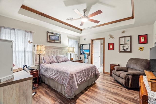11609 SW 14th St, Yukon, OK 73099 - bedroom featuring a tray ceiling, light wood finished floors, baseboards, crown molding, and a ceiling fan