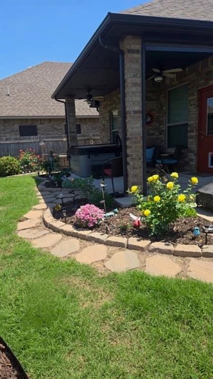 11609 SW 14th St, Yukon, OK 73099 - view of home's exterior featuring a ceiling fan, a hot tub, a shingled roof, and a patio area