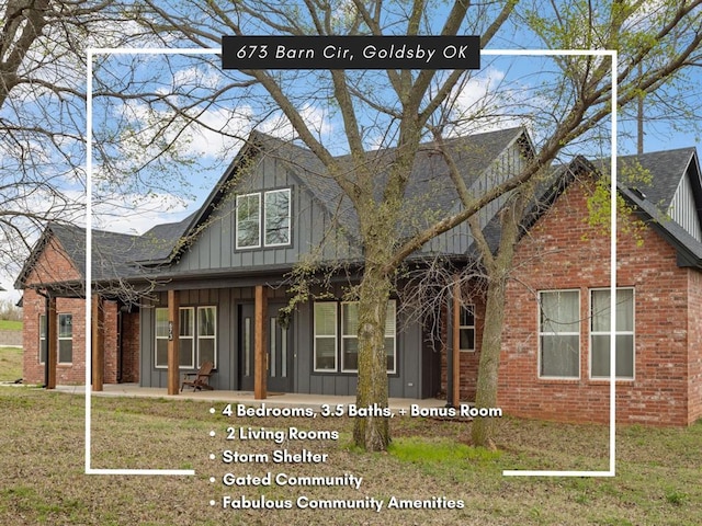 view of front of home featuring board and batten siding, a front yard, and brick siding
