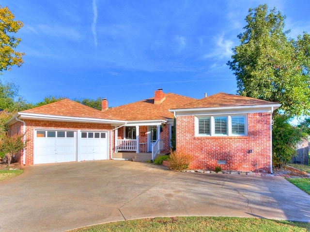 1821 Coventry Ln, Nichols Hills, OK 73120 - view of front of home with brick siding, driveway, an attached garage, and a chimney
